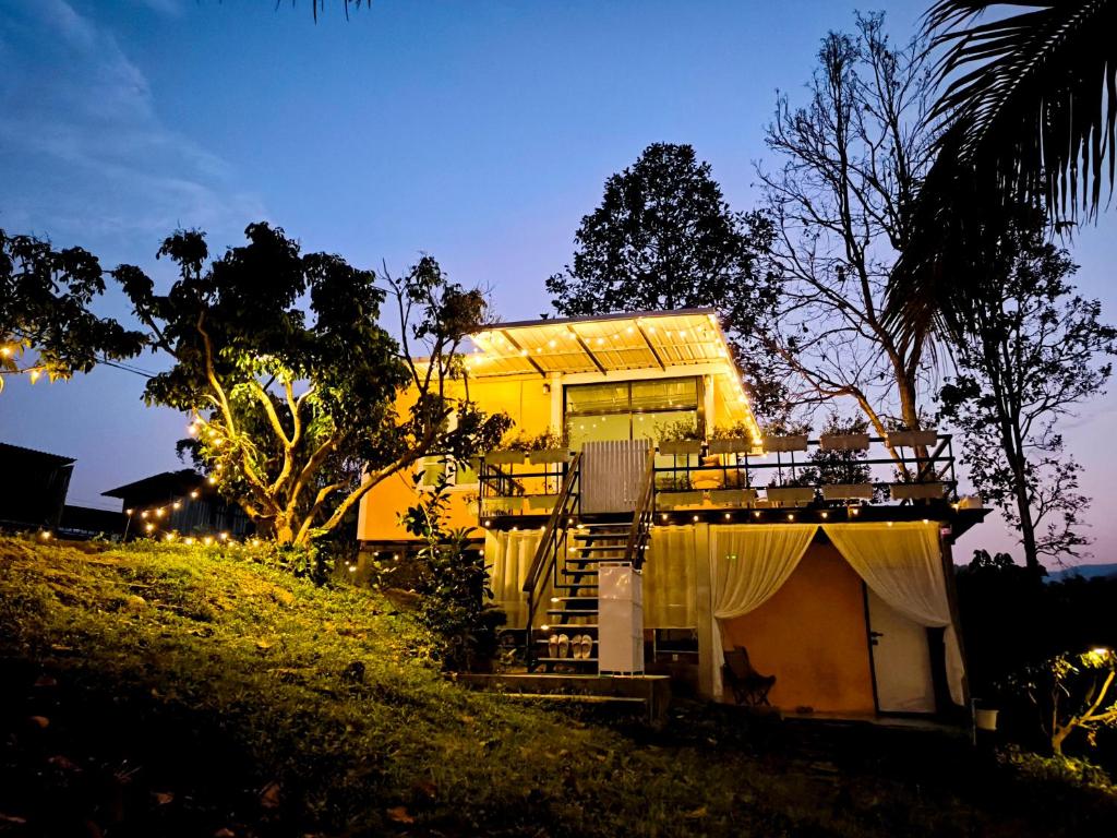 a house on a hill with a dog sitting on the porch at De Napa - Private Homestay in Ban Mae Na