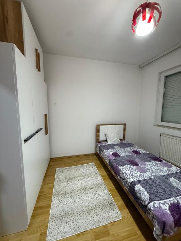 a bedroom with a bed and a rug at Rental House in Mitrovica