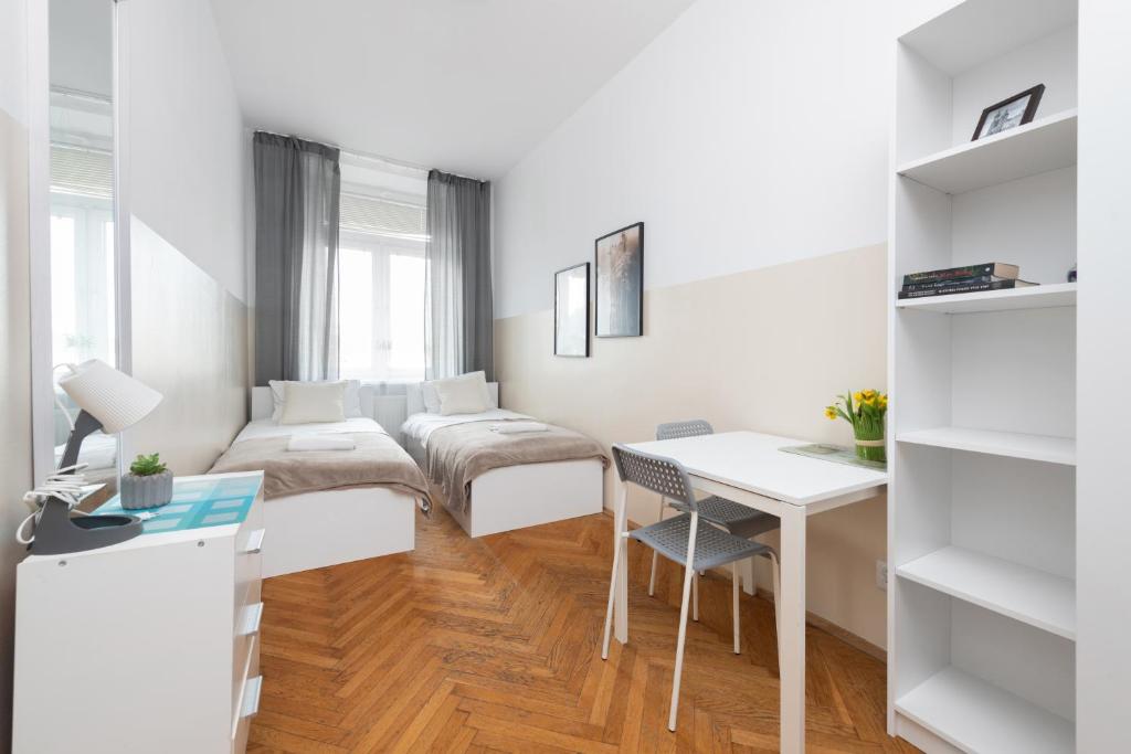 a small white room with a desk and a bed at Rooms Nearto Main Square in Krakow