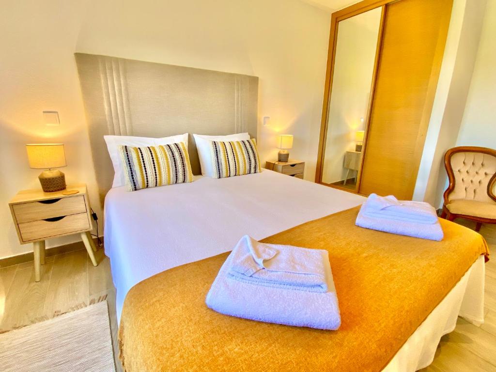 a bedroom with a large bed with towels on it at Quinta das Andorinhas in Carvoeiro