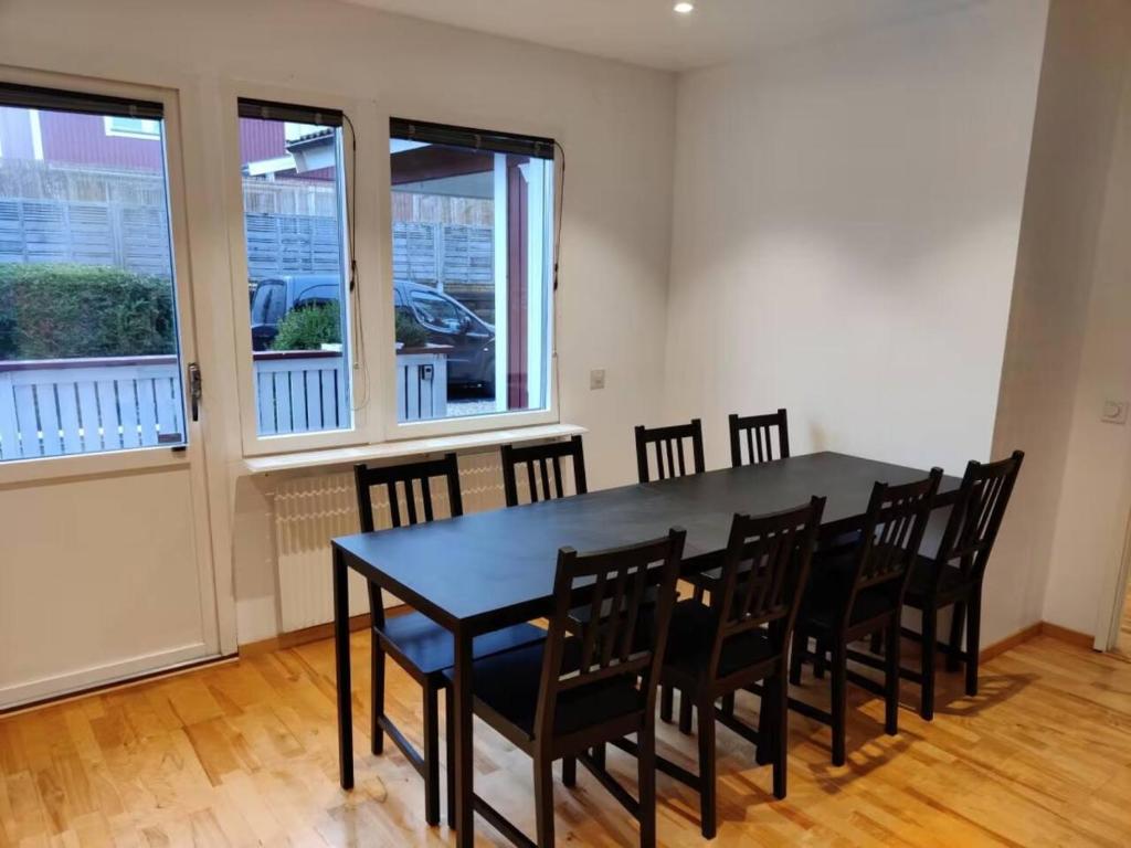 a dining room with a black table and chairs at Workers Stay - Temporary House Gothenburg in Gothenburg
