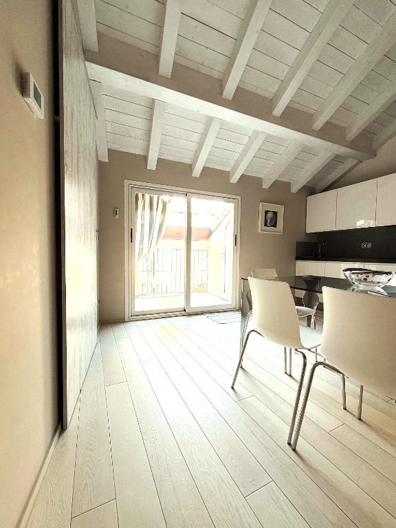 a living room with a table and chairs and a kitchen at Budello di Alassio, ampio appartamento con box vicino al mare in Alassio