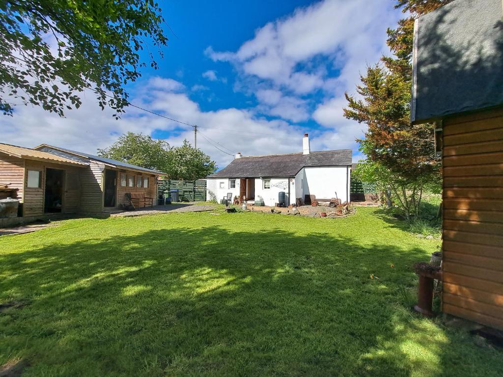 a yard with a house and a house at Rose Cottage Solway Self Catering in Cardurnock