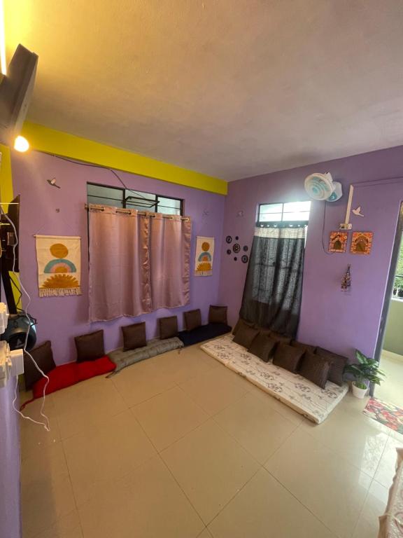 a living room with purple walls and a window at Hazz Backpackers Hostel in Shillong