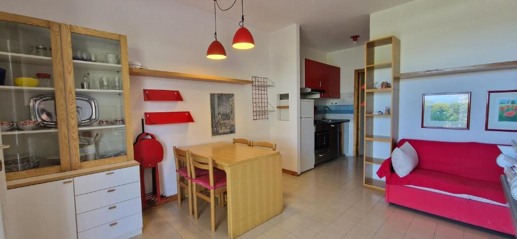 a kitchen and a living room with a red couch at Best Holidays Pineta in Marcelli