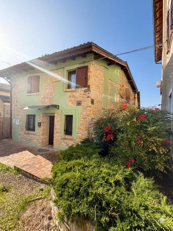 une maison en briques avec des fleurs devant dans l'établissement La Ca' Tòrta - Rustico ristrutturato, à Neviano degli Arduini