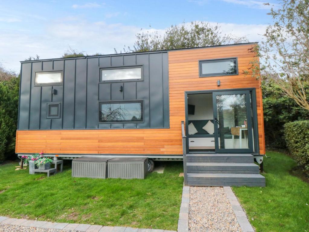 a black and orange tiny house in a yard at The Tiny Home in Yarm