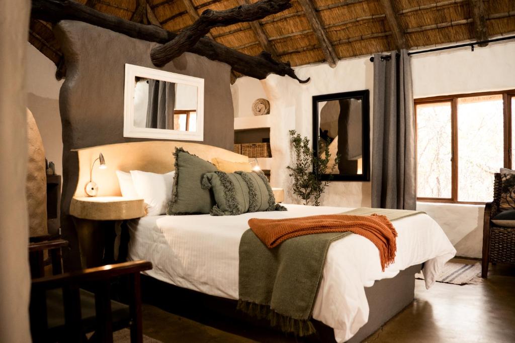 a bedroom with a large bed with green pillows at LittleBush Private Lodge in Hoedspruit