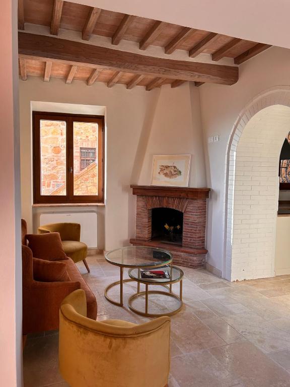 a living room with a table and a fireplace at CasaGozzante in Pienza