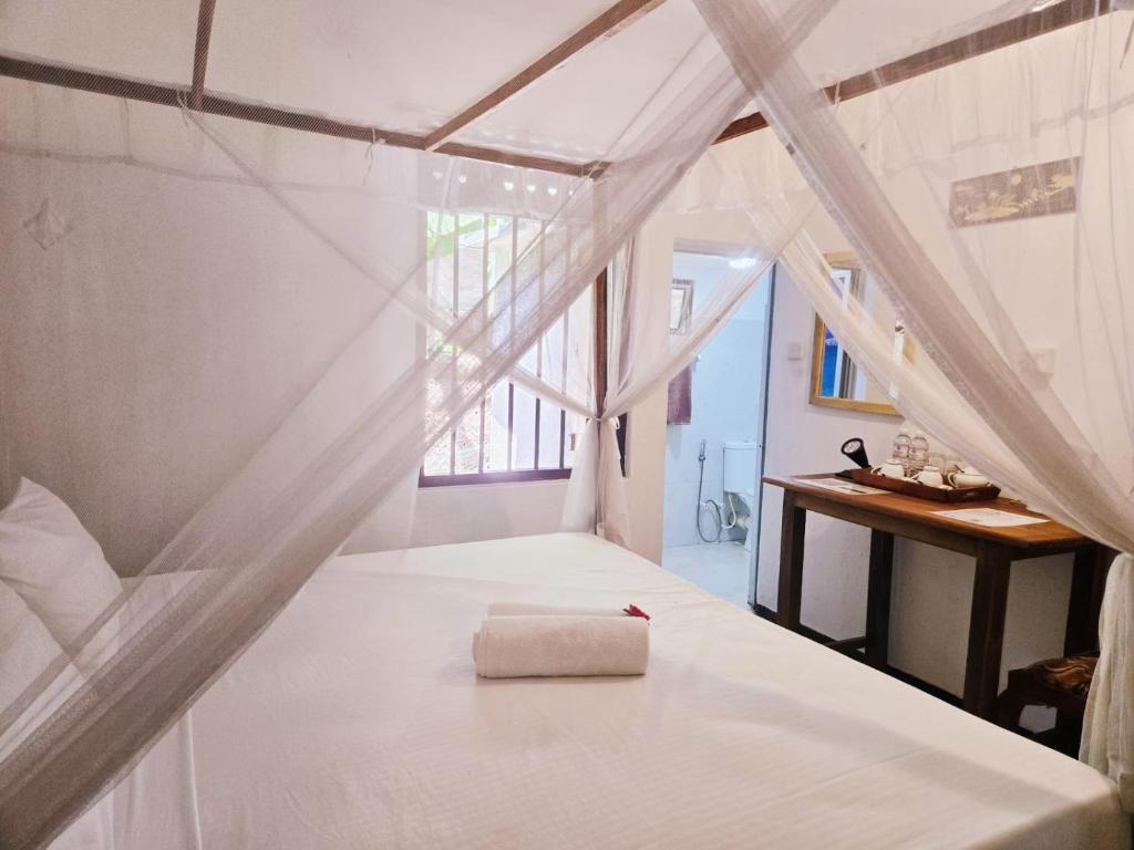 a bedroom with a white bed with a box on it at The Coast Haven in Tangalle