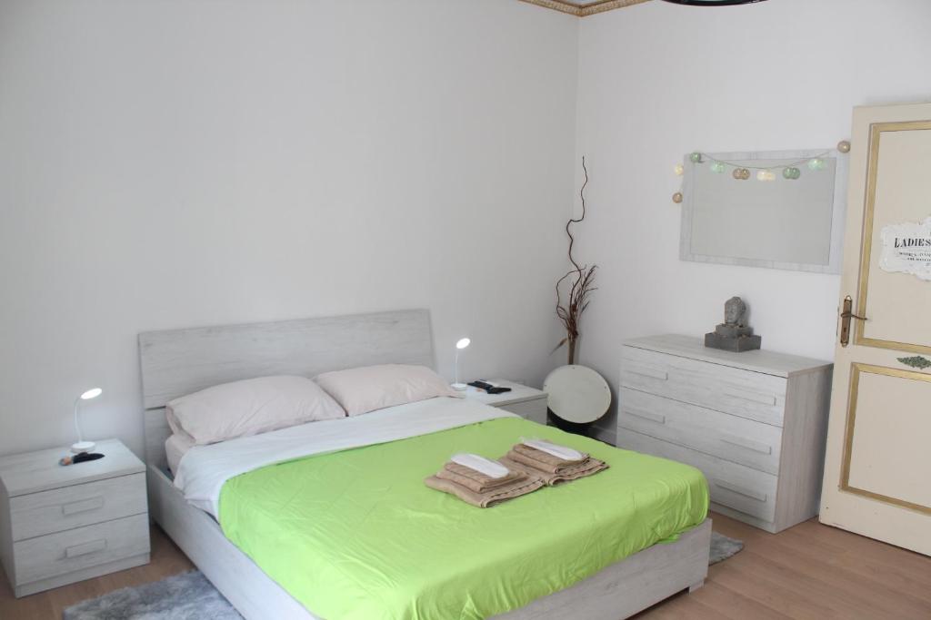a bedroom with a bed with green sheets and towels at La Vinella in Lamezia Terme