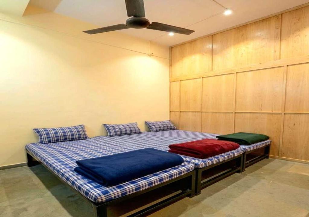 a bed with two pillows on it in a room at Vishram Yatri Niwas in Kolhapur