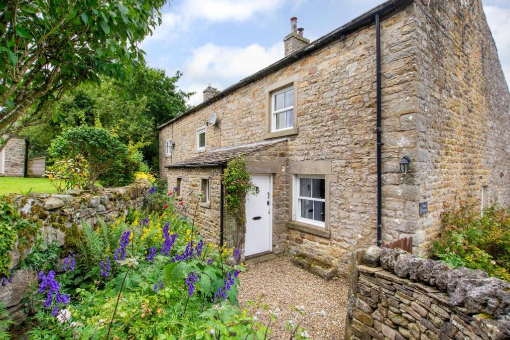 an old stone house with a garden in front of it at 3 Bed in Caldbergh oc-ds911 in Caldbergh