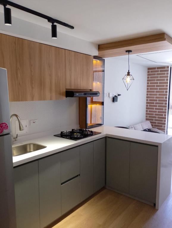 a kitchen with a sink and a stove top oven at Boreal House in Manizales