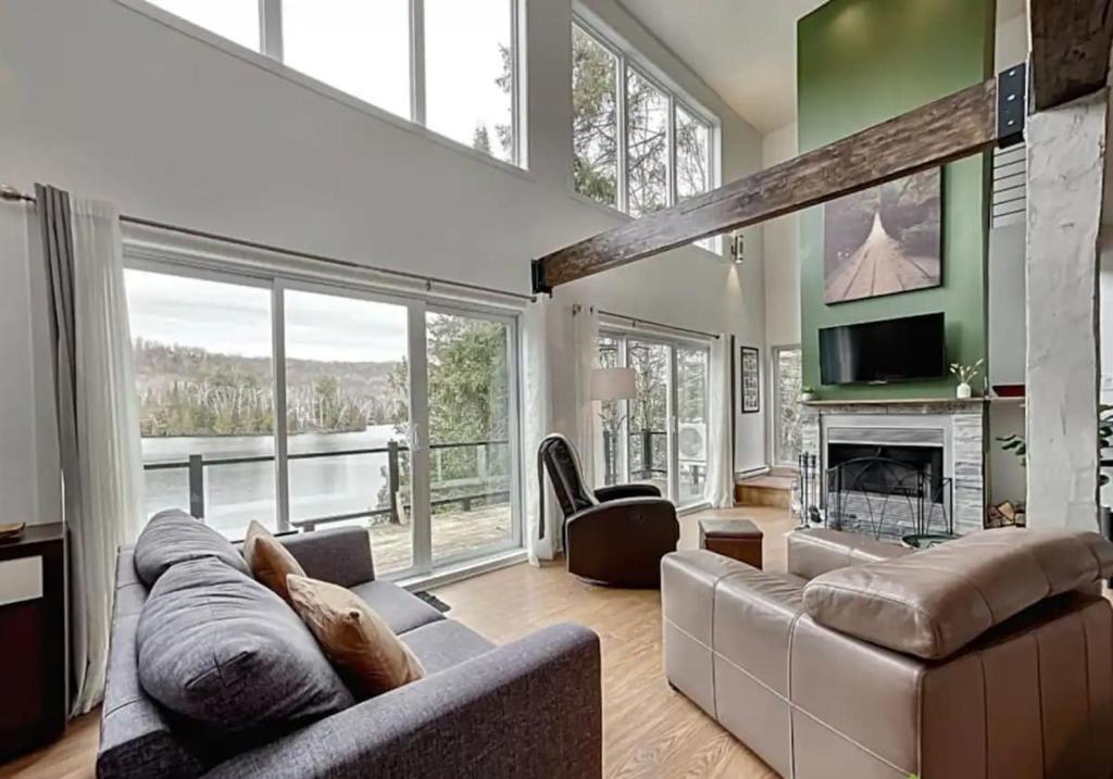 a living room with a couch and a fireplace at Lakeside Lodge at Tremblant in Brébeuf