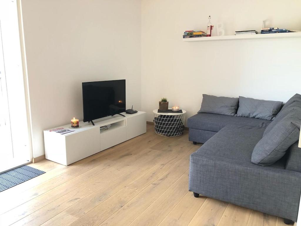 a living room with a couch and a flat screen tv at Dream Home - Kapuziner Platz in Brunico