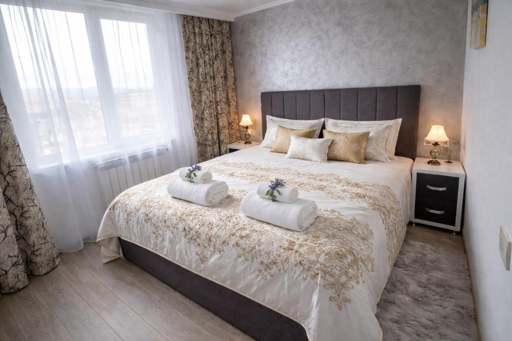a bedroom with a bed with two towels on it at Delux Flat Straja in Lupeni