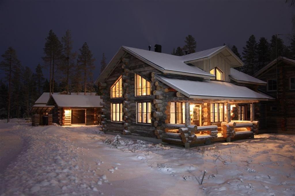 a log cabin in the snow at night at Runoilevi B3 Visit Levi in Sirkka