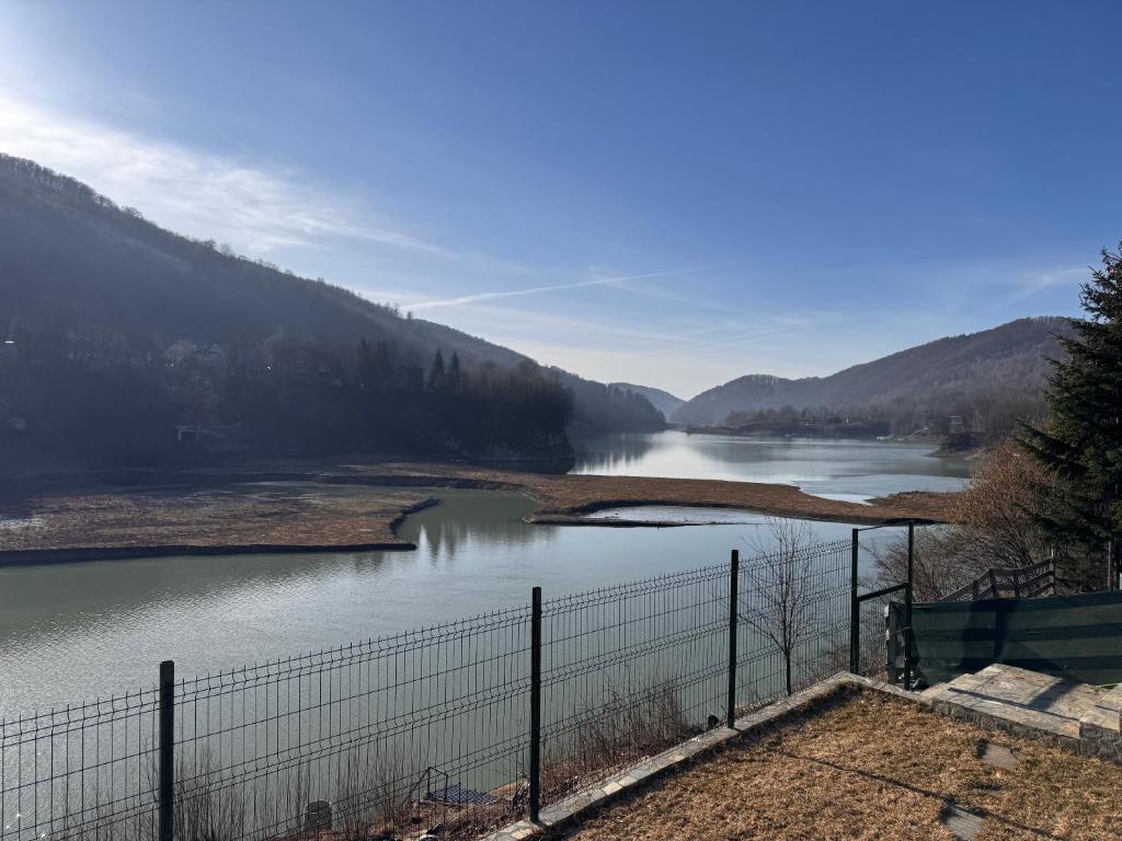 a view of a river with a fence at Doftana Lake House in Teşila