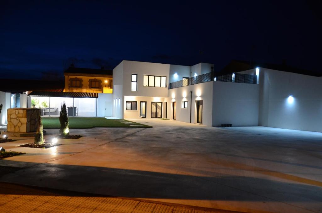 a large white house with a driveway at night at Búnker de Pepa in Zamora