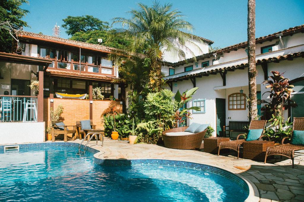 a swimming pool in front of a house at Casa Aldeia Paraty in Paraty