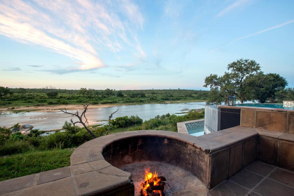 a fire pit with a river in the background at Buffalo Brooke in Hectorspruit