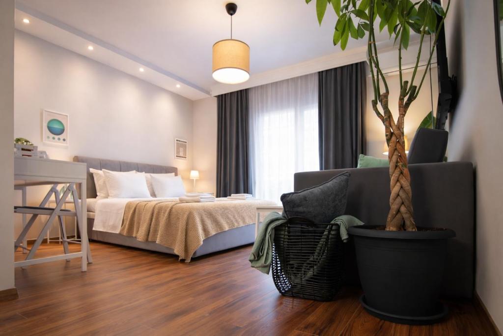 a bedroom with a bed and a potted tree at Escape Central Stay with Parking - Meno Homes 4A in Xanthi