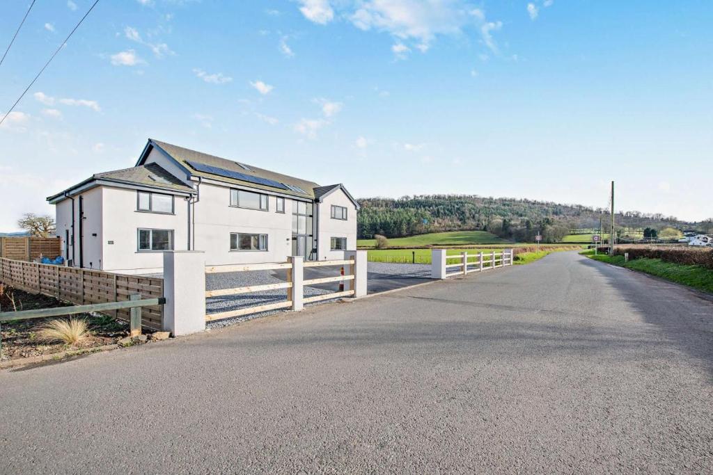 a white house with a fence on the side of a road at 2 Bed in Llanarthney oc-c28877 in Llanarthney