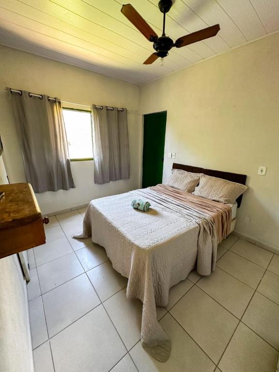 a bedroom with a bed and a ceiling fan at Casinha Charmosa in Miguel Pereira
