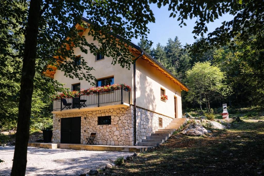 ein Gebäude mit einem Balkon und einer Treppe davor in der Unterkunft House sid forest in Otočac