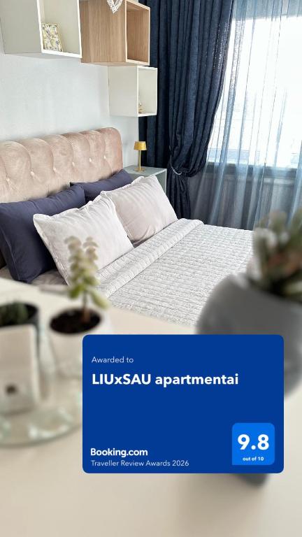 a bedroom with a bed with a blue sign on it at LIUxSAU apartmentai in Mažeikiai
