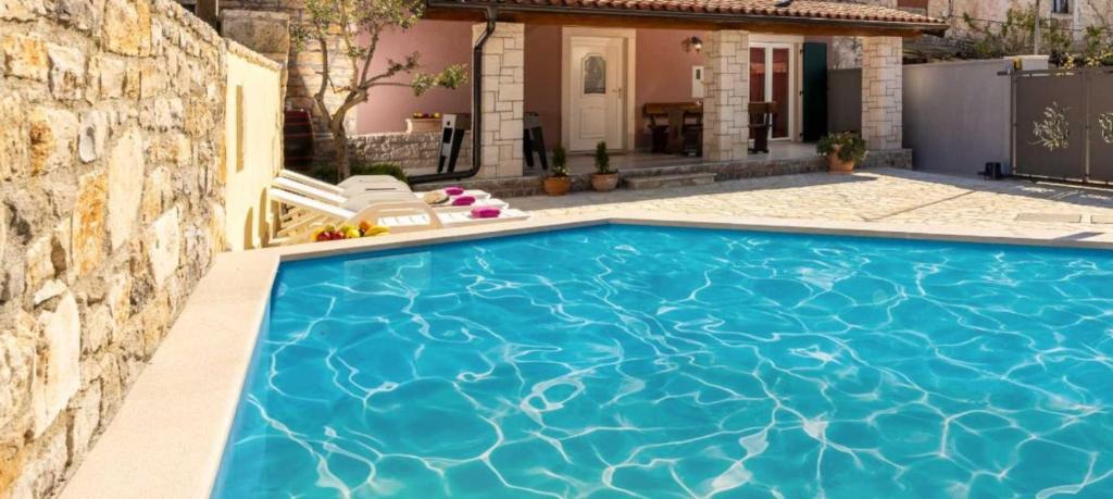 a swimming pool in front of a house at Casa Mia By Kompas Villas in Butkovići