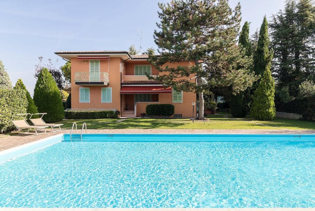 a villa with a swimming pool in front of a house at Appartamento Di Morgana Sirmione in Sirmione
