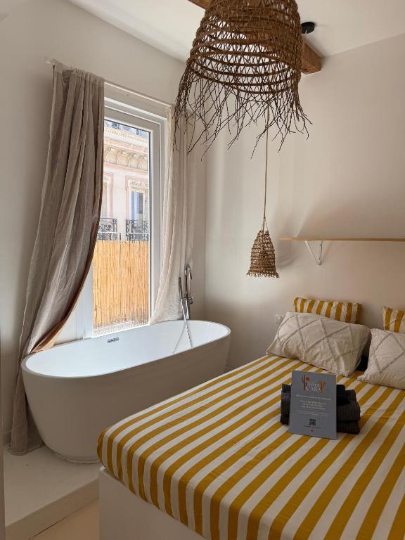 a bedroom with a bed and a bath tub and a window at LaFrenchCasa Canebière in Marseille