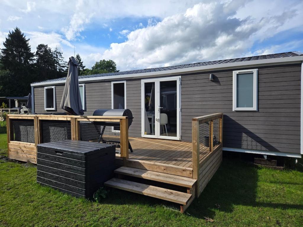 a deck with an umbrella on a tiny house at Eekhoorn 7 in Gasselte