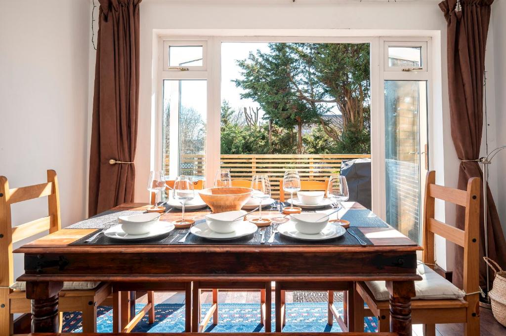 a dining room with a wooden table with chairs at Spacious 4Bed Home with Decked Garden Forest Hill - Pass the Keys in London