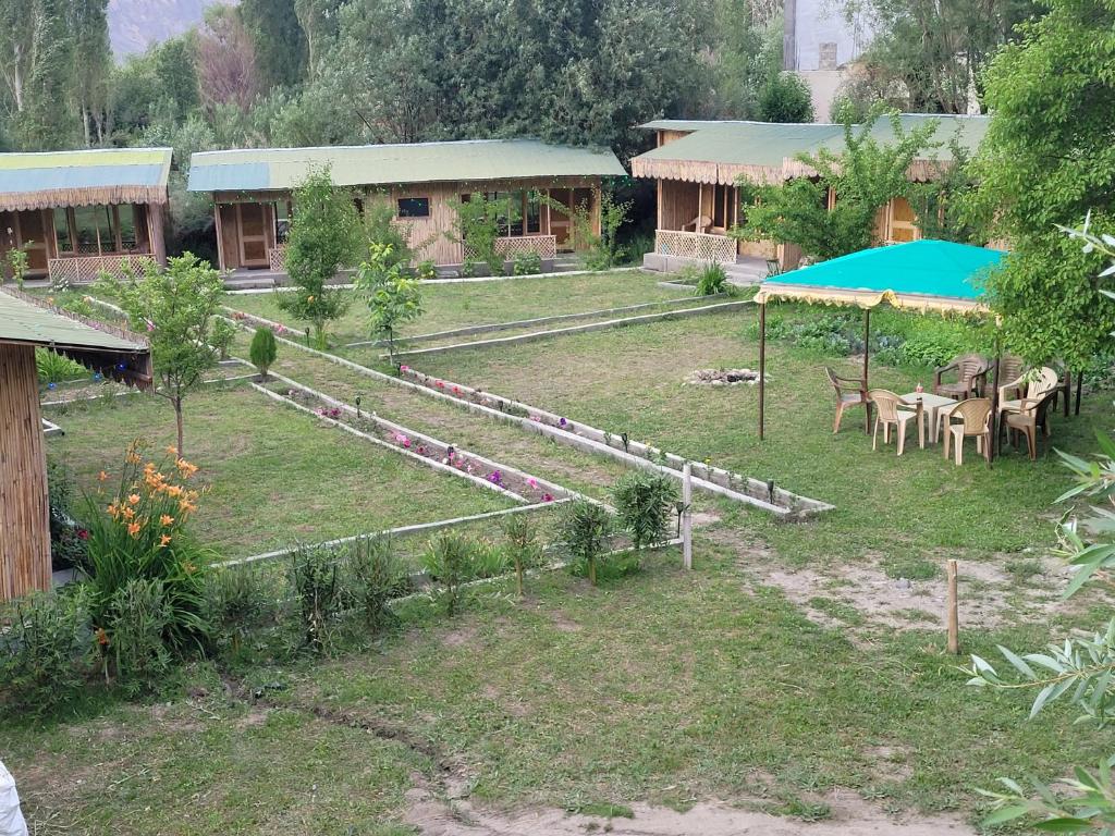 a house with a yard with tables and umbrellas at The Sylvan Hut in Leh