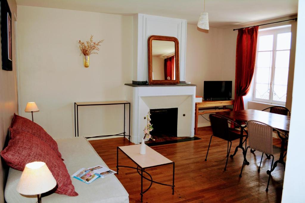 a living room with a couch and a table and a mirror at Petite Roche centre historique La Rochelle in La Rochelle