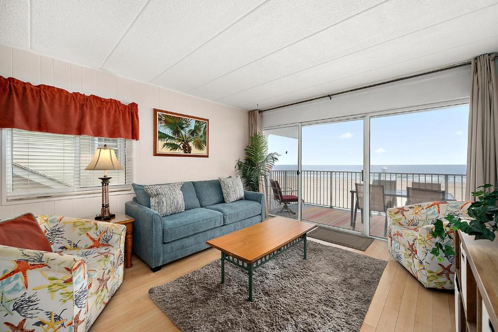 a living room with a couch and a table at El Capitan 206 - Dolphin Watch in Ocean City
