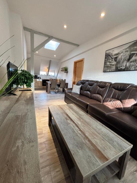 a living room with a leather couch and a coffee table at Ferienwohnung Elbbrise in Riesa