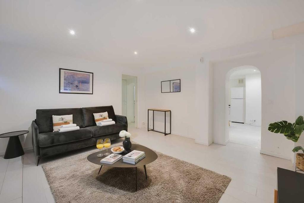 a living room with a black couch and a table at Spacious apartment-2BR-4P in Le Kremlin-Bicêtre