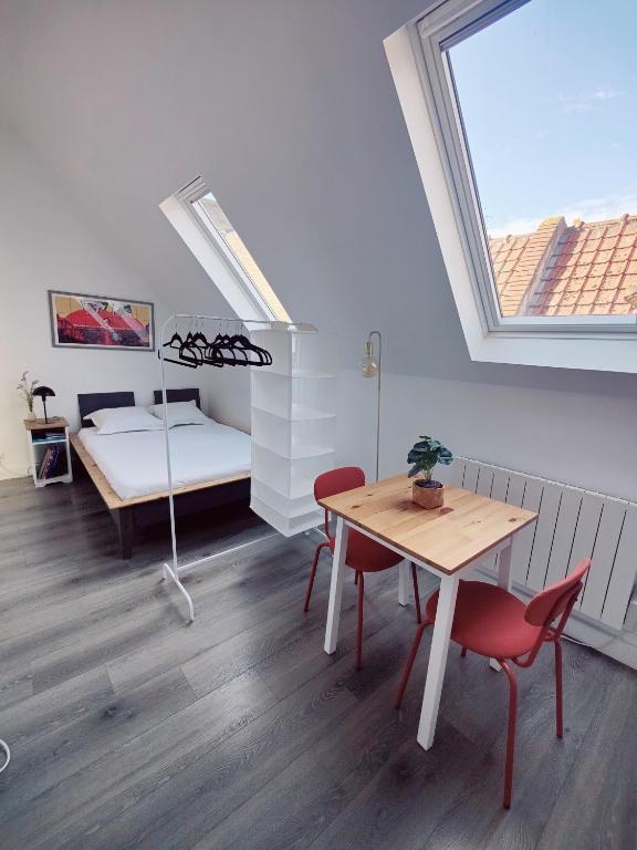 a room with a table and a bed and a window at Passage des arts - Vieux Lille - 2 personnes in Lille