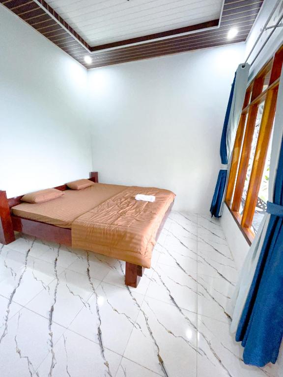 a bedroom with a bed in the corner of a room at Nerly's Panorama in Bukit Lawang