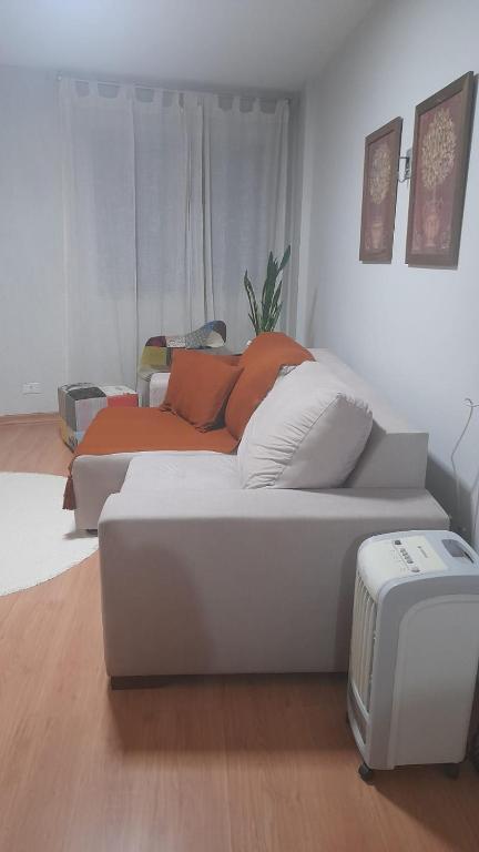 a white couch with pillows on it in a room at Apartamento Inteiro em Setor Nobre in Goiânia