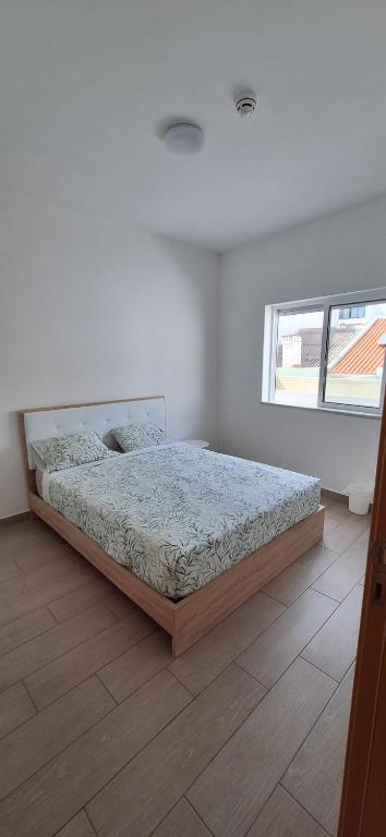 a bedroom with a bed in a white room at Blue Sardine Hostel in Portimão
