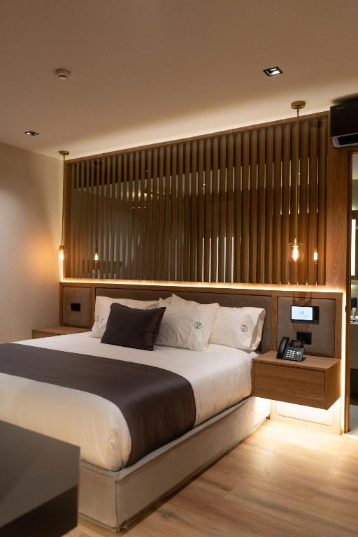 a bedroom with a large bed and a television at Punto Suites Periférico Sur in Mexico City