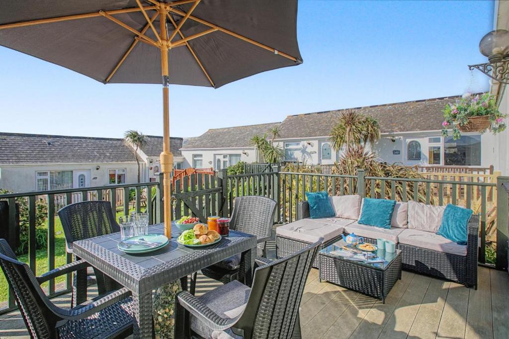a patio with a table and chairs and an umbrella at 2 Bed in Mullion oc-k7968 in Mullion