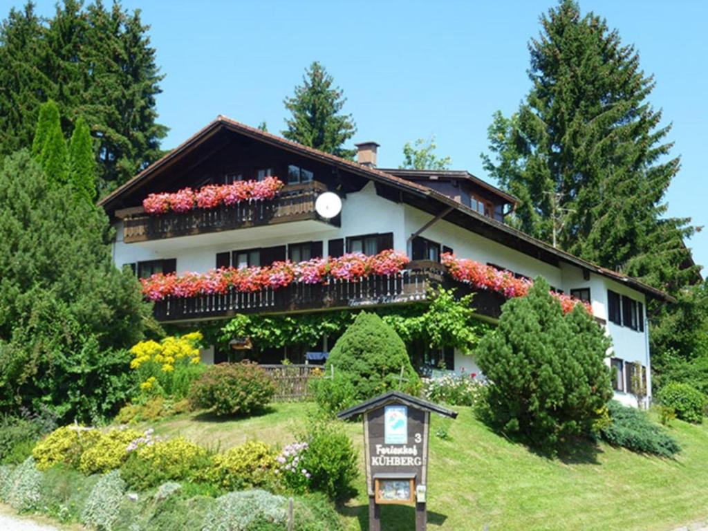 a building with flowers and a sign in front of it at Ferienhof Kühberg mit schönstem Panoramablick in Blaichach