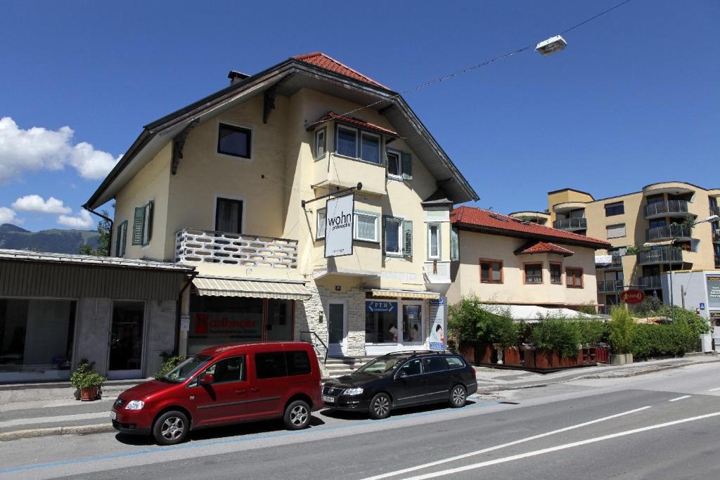 two cars parked in front of a building on a street at Haus Rieder in Wörgl