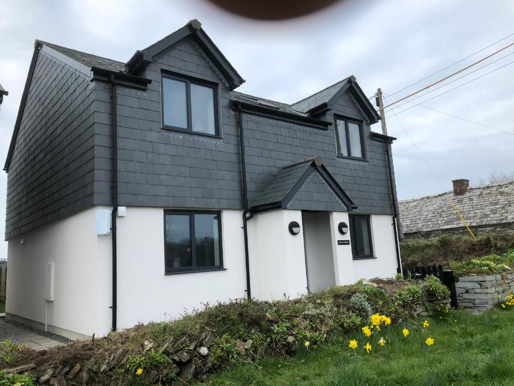 a white house with a black roof at Gwel Owrek in Tintagel